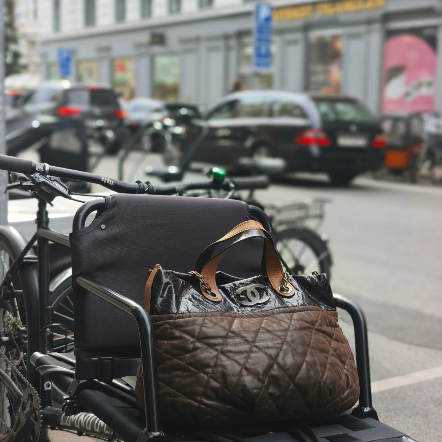 A pre-loved Chanel tote in a bicycle basket on a Copenhagen street